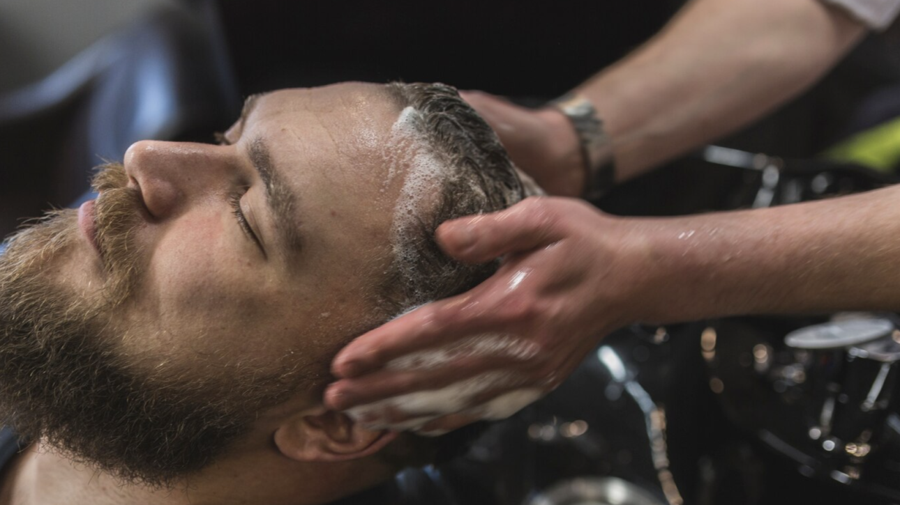 Lavando el pelo a un hombre en la peluquería de caballero en Salamanca
