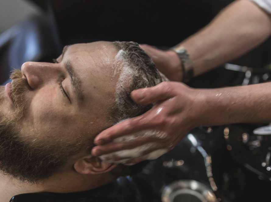 lavando el pelo a un hombre en una peluqueria de caballero en Salamanca